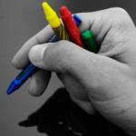 Una mano scrive parole colorate